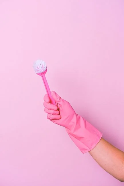 services-04 Anonymous man in yellow latex gloves and a dark T-shirt wiping a bathroom mirror with a paper napkin